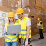 warehouse workers consult delivery plans using lap 3e6pbvc.jpg